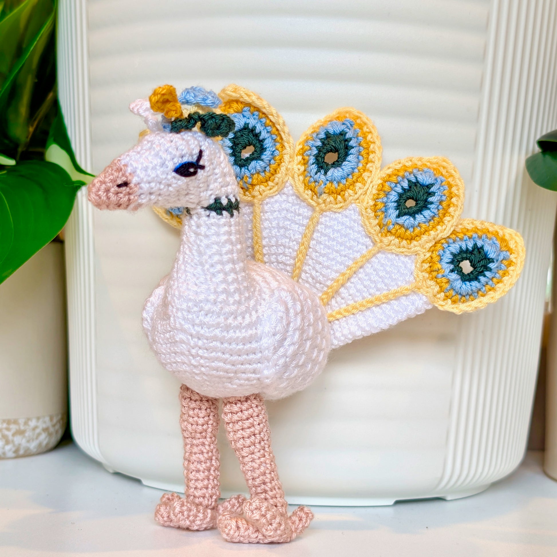 White crocheted peacock with Creme Brulee, Light Blue, and Evergreen colored accents