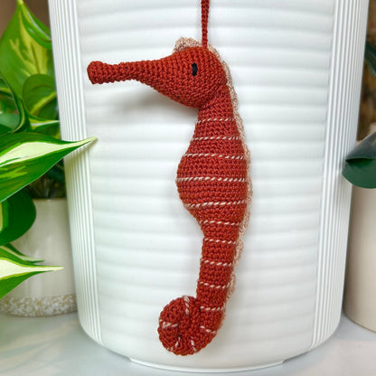 Crocheted terracotta seahorse charm with beige stripes 