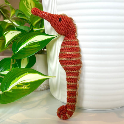 crocheted terracotta seahorse with tan stripes