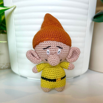 Crocheted troll wearing a ginger brown hat and a chartreuse outfit