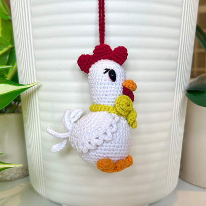 left side profile of white crocheted chicken charm with a ruby red comb and a curly chartreuse scarf
