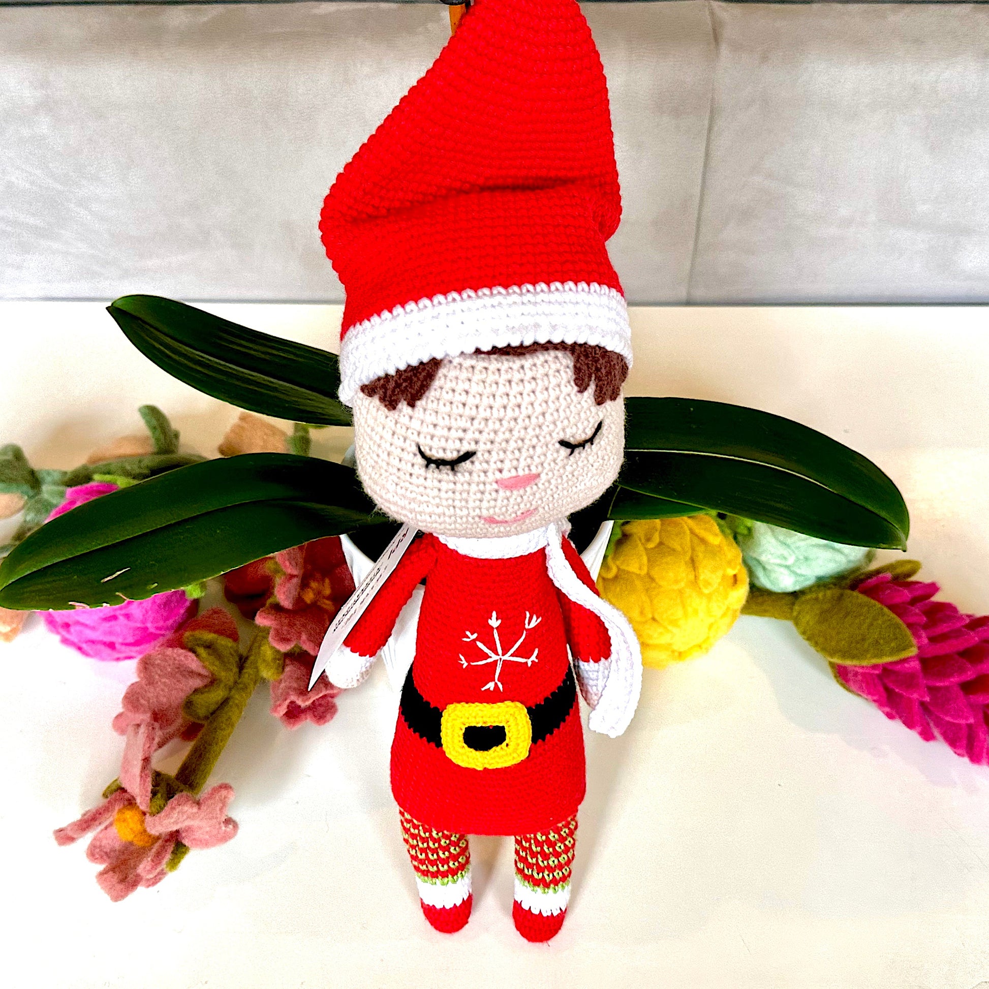 Crocheted plush elf doll in red at and outfit.  
