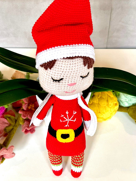 Crocheted plush elf toy with a red hat and outfit.