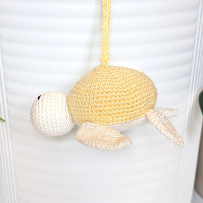 Crocheted sea turtle charm keychain with a dusty creme brulee colored shell