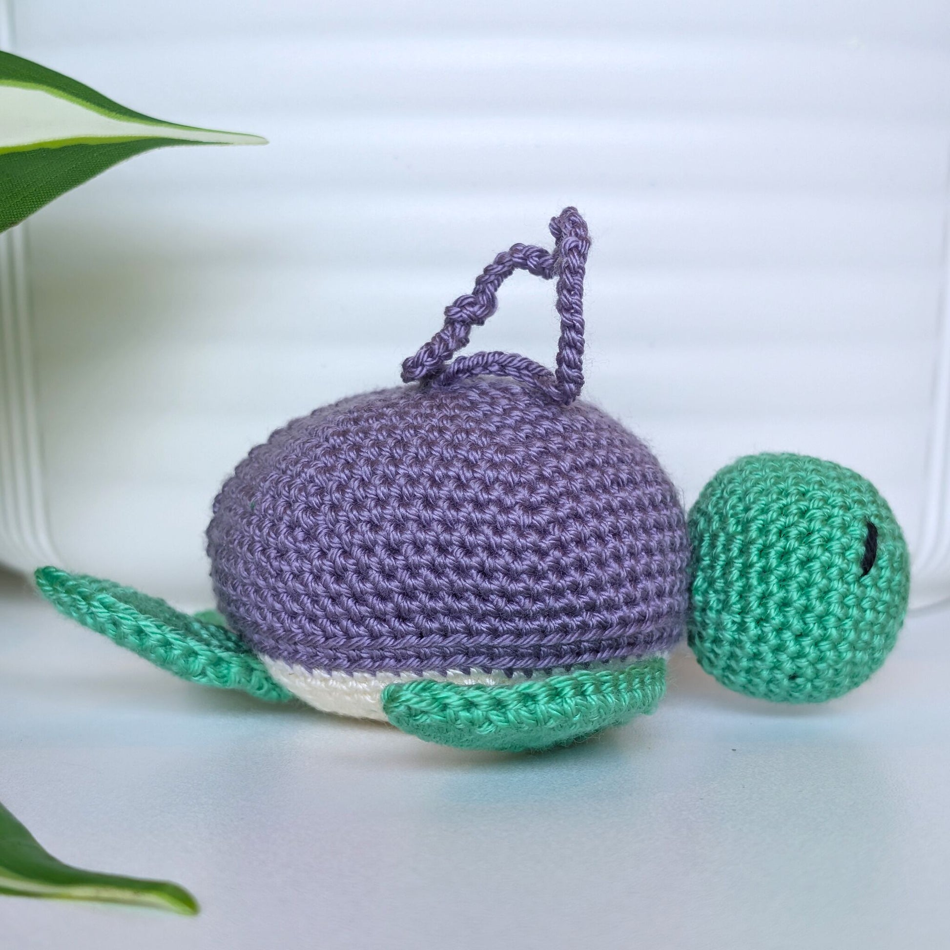 Crocheted jade green body sea turtle with light amethyst or purple shell and a string