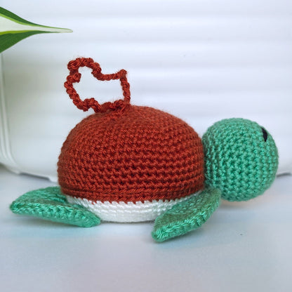 Crocheted jade green body sea turtle with terracotta shell and a string