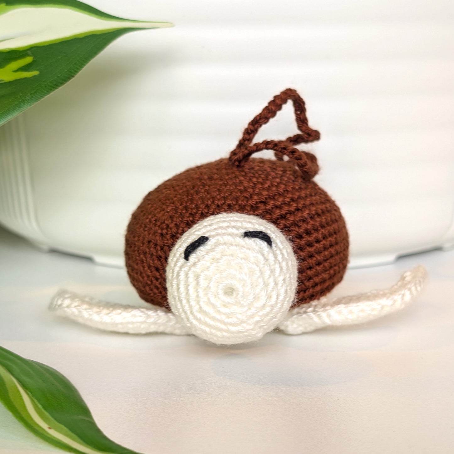 Crocheted sea turtle charm keychain with a brown shell