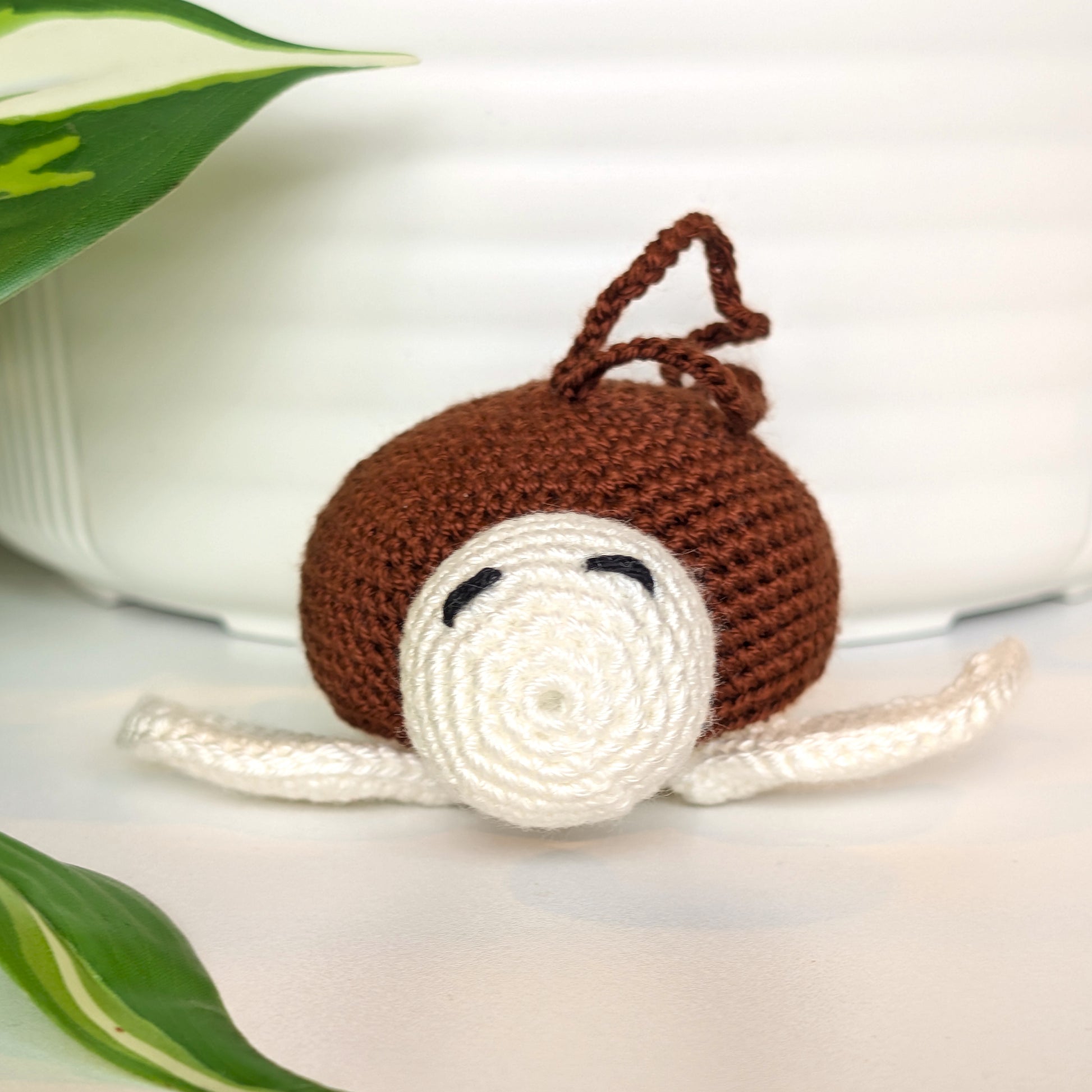 Crocheted sea turtle charm keychain with a brown shell