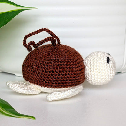 Crocheted sea turtle charm keychain with a brown shell