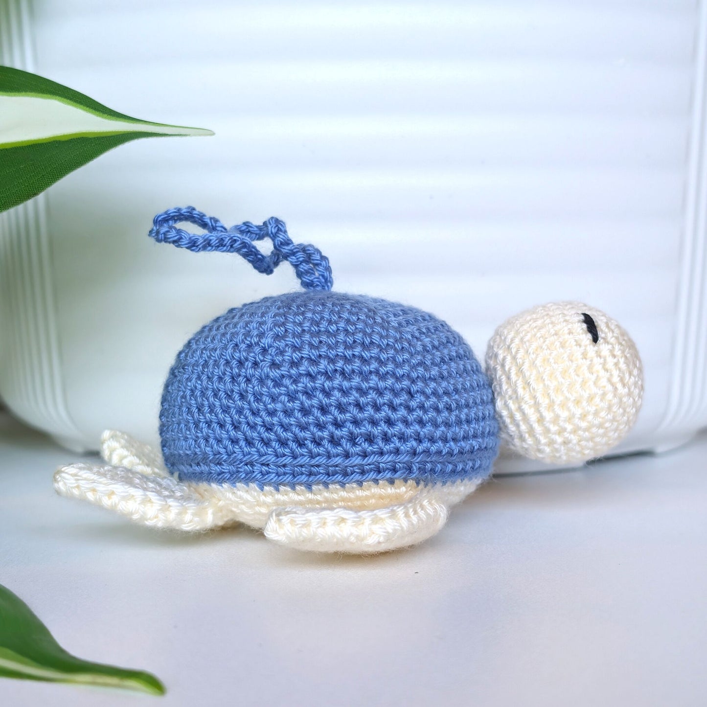 Crocheted sea turtle charm keychain with a cornflower blue shell