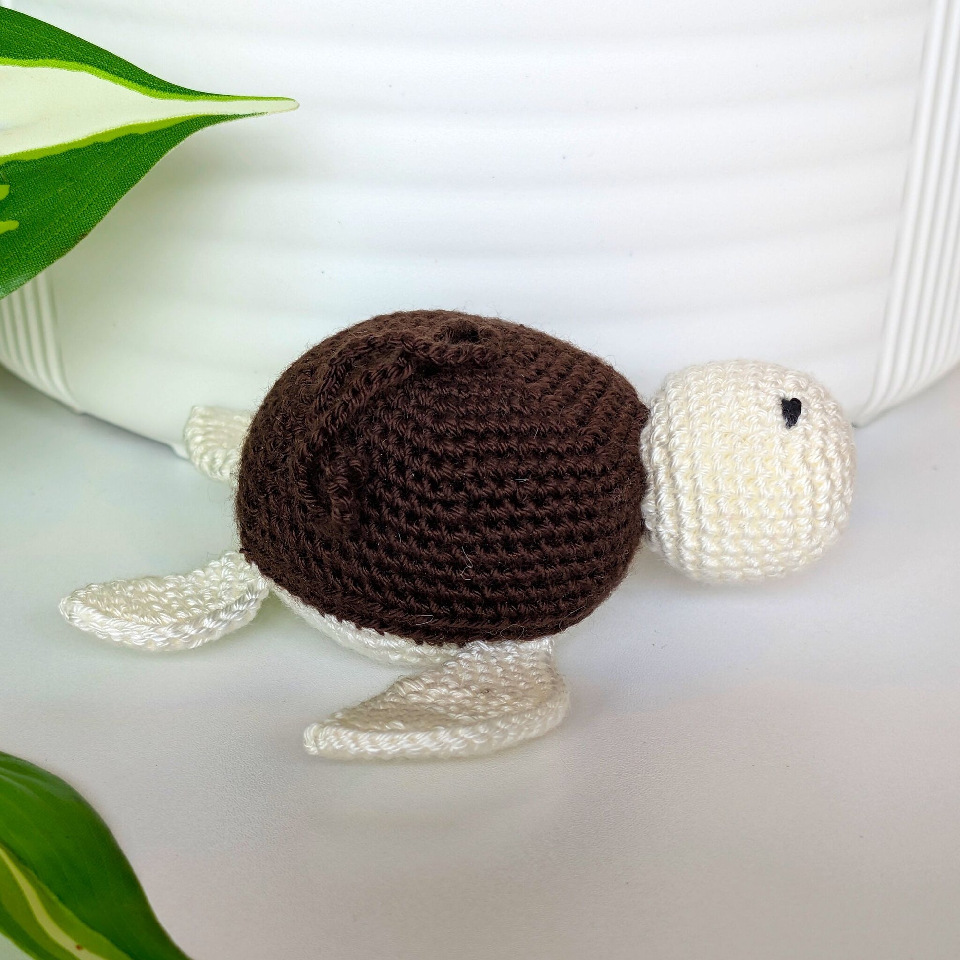 Crocheted sea turtle charm keychain with a dark brown shell