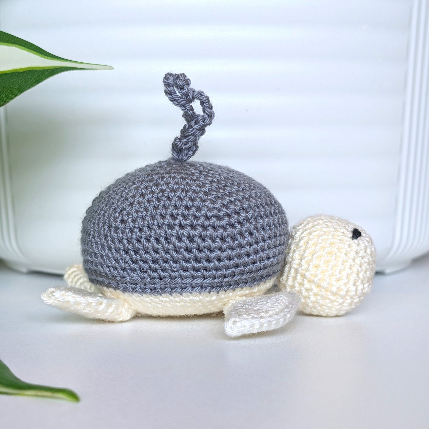 Crocheted sea turtle charm keychain with a dark gray shell