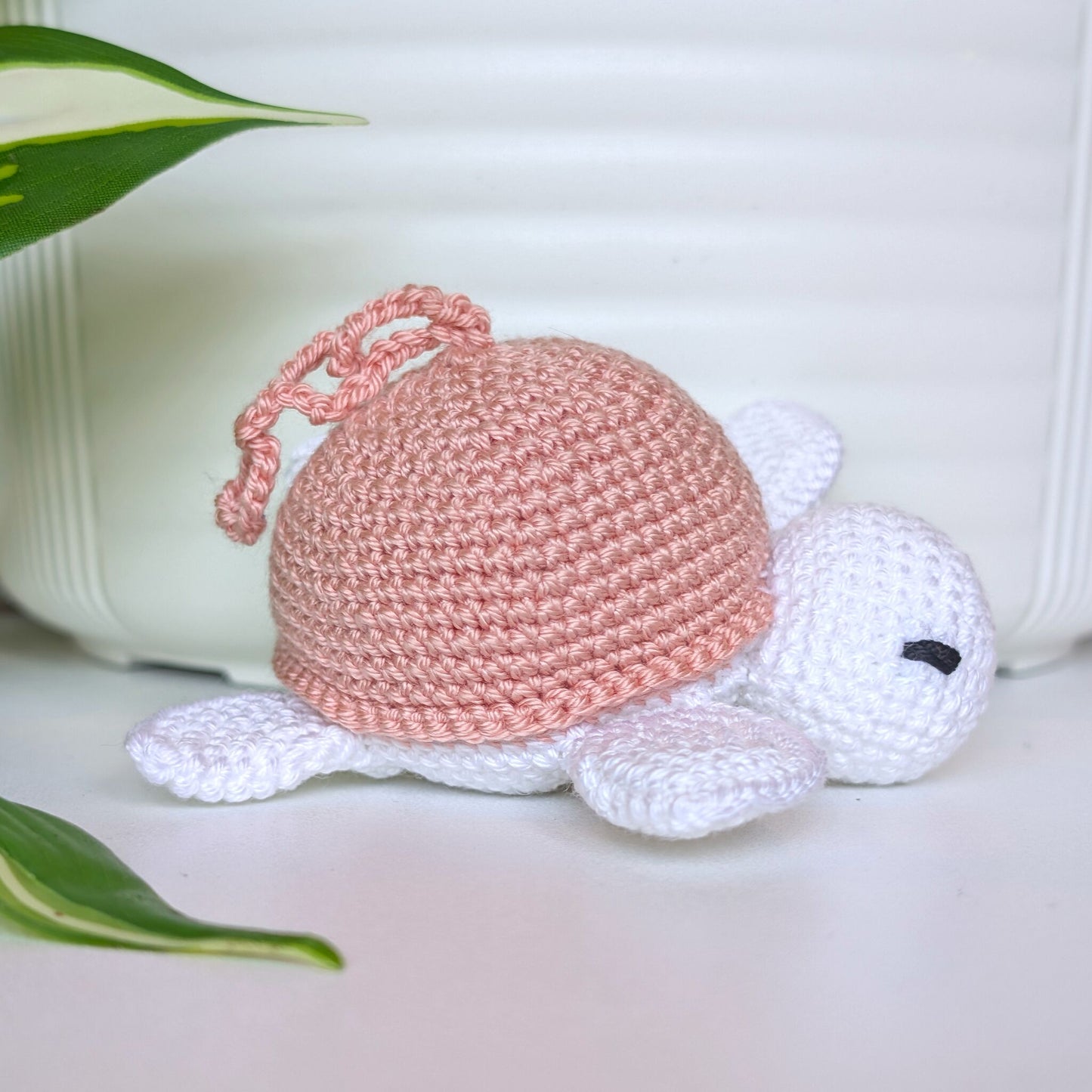 Crocheted sea turtle charm keychain with a dusty pink shell