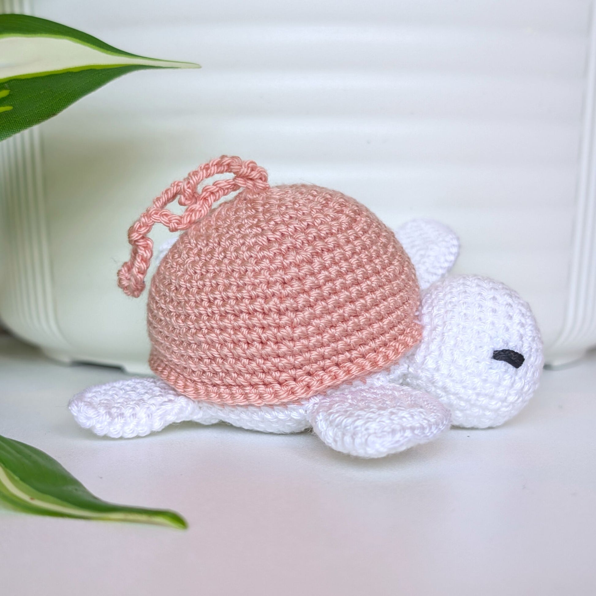 Crocheted sea turtle charm keychain with a dusty pink shell