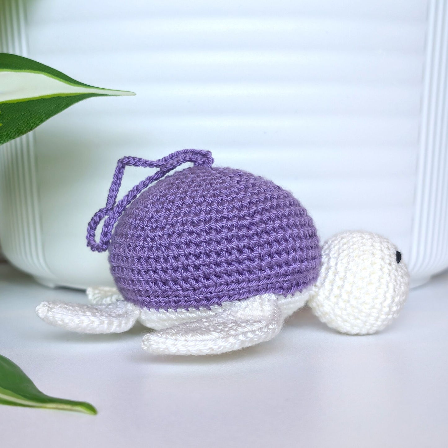Crocheted sea turtle charm keychain with a light amethyst or lavender shell