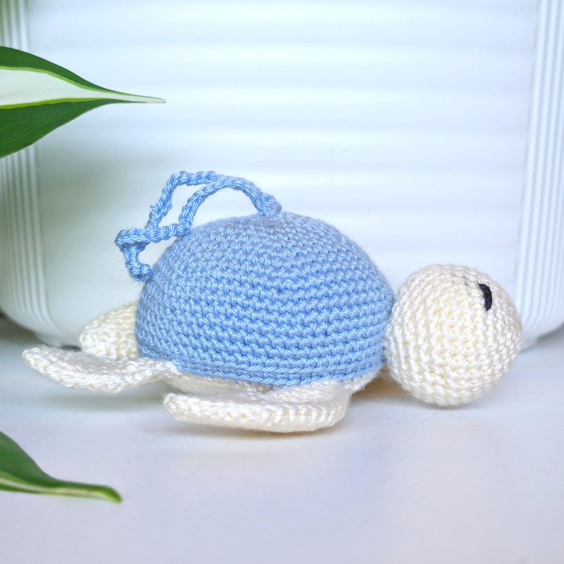 Crocheted sea turtle charm keychain with a sky blue shell