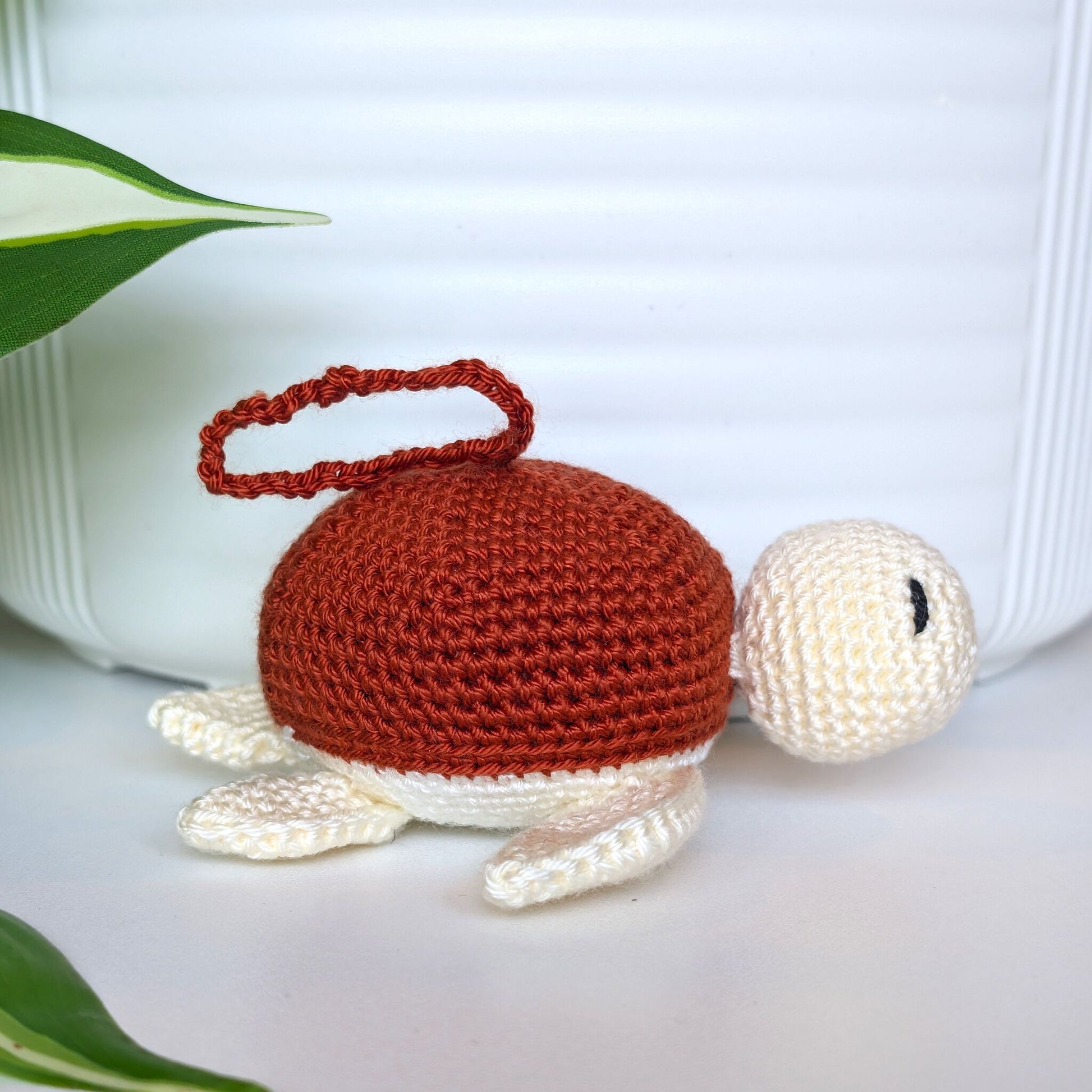 Crocheted sea turtle charm keychain with a terracotta shell