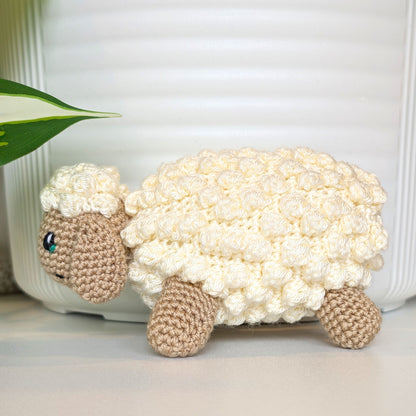 Crocheted cream fleece sheep plush with beige body and emerald green eyes