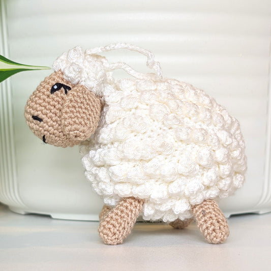 Crocheted sheep plush with beige body with an attached sting