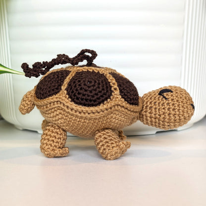 Crocheted turtle charm with brown shell and beige body