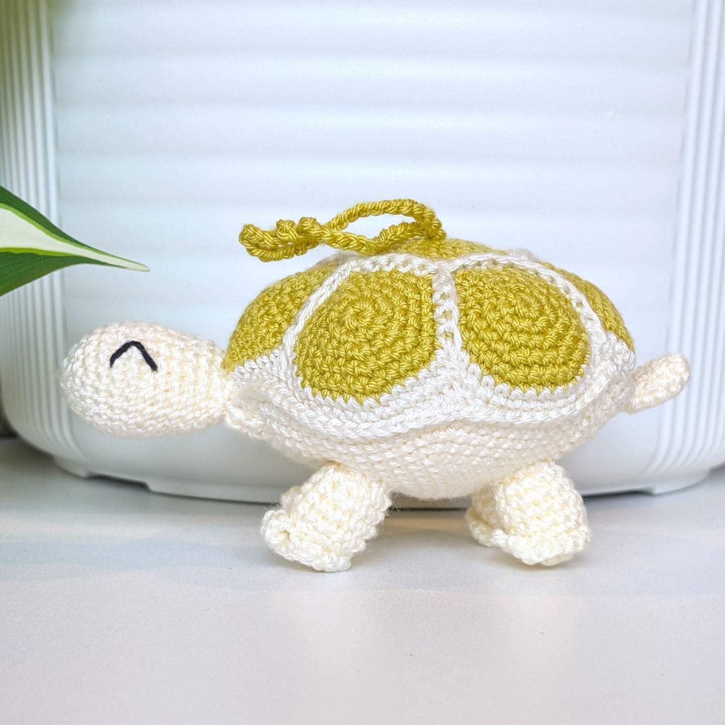 Crocheted turtle charm with chartreuse green shell and white body