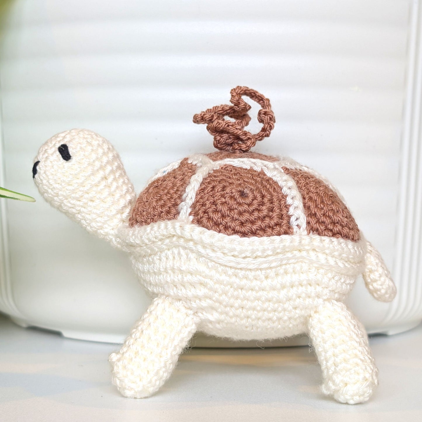 Crocheted turtle charm with a dusty pink shell with white body