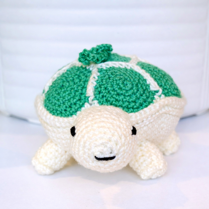Front view of crocheted turtle toy with green shell